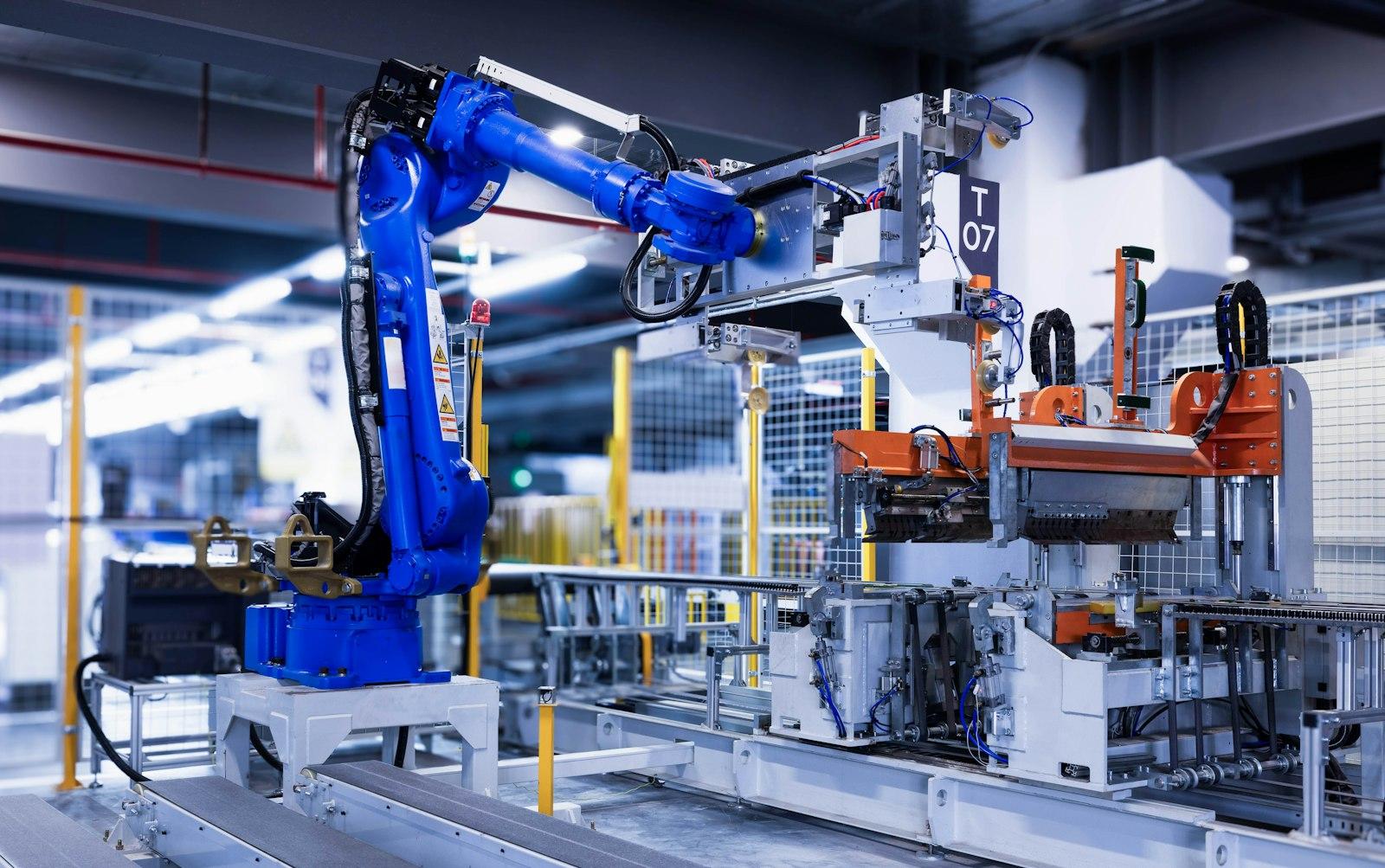 A blue industrial robot arm working on a factory line